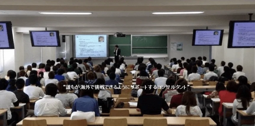 大学講義での登壇風景。数百名の聴講生を前に講義するKent